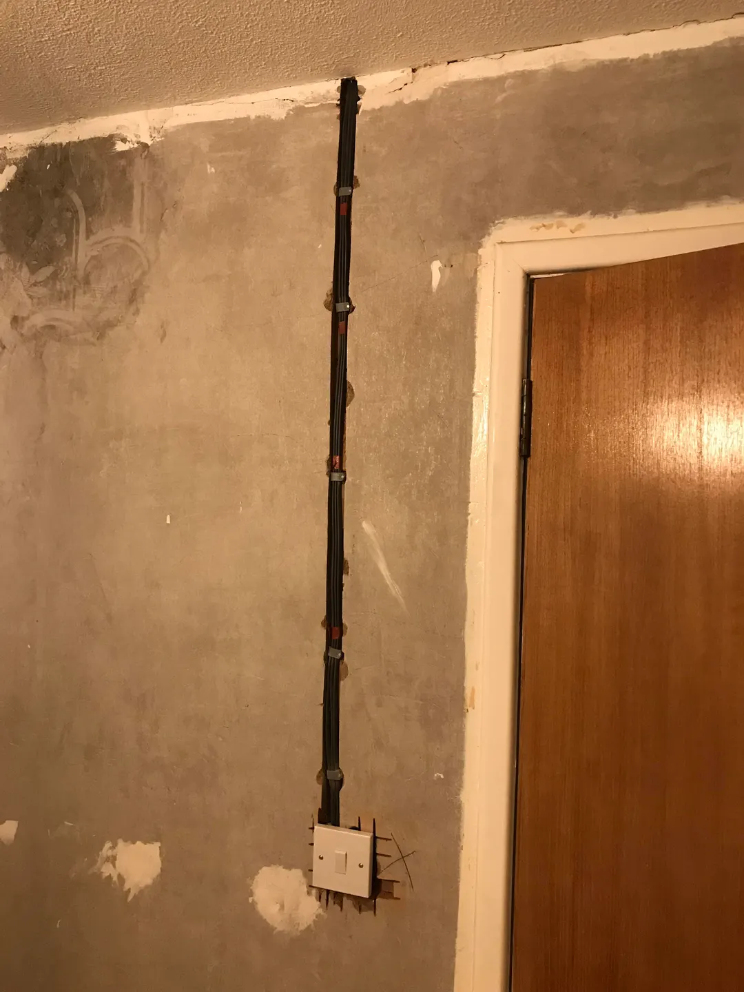 Cables chased into a wall above a door during a rewire, ready for plaster